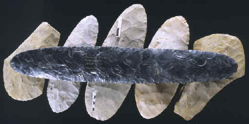 Large obsidian biface laying on 5 large spades.