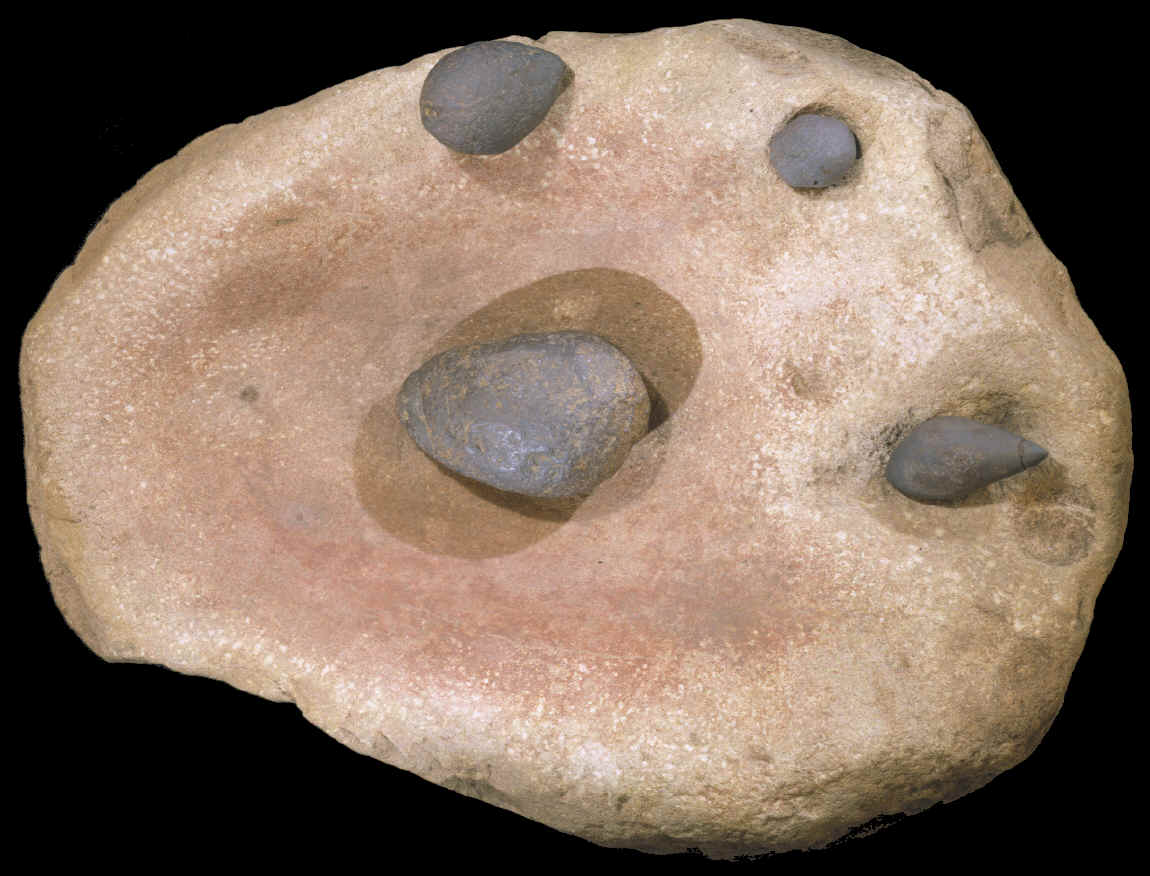 Large sandstone grinding stone stained with red ochre.